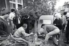 403113 Afbeelding van enkele buurtbewoners die een tijdens de storm van 12 mei 1983 omgewaaide boom aan de ...